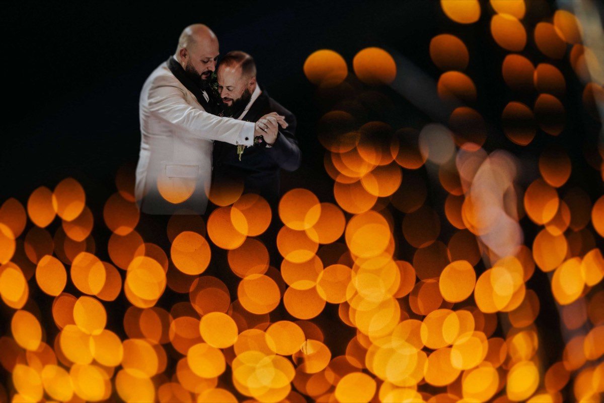 Pareja bailando rodeada de luces desenfocadas
