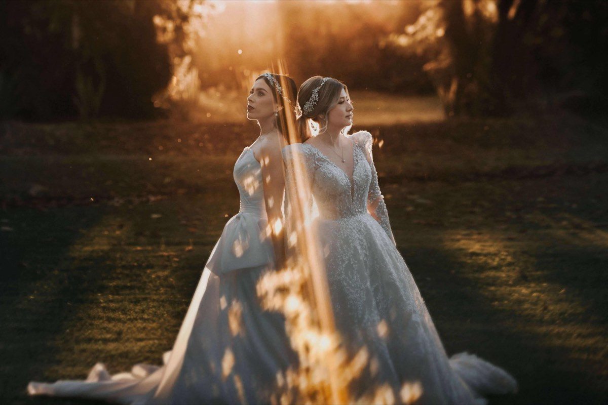 Dos novias tomadas de la mano al atardecer