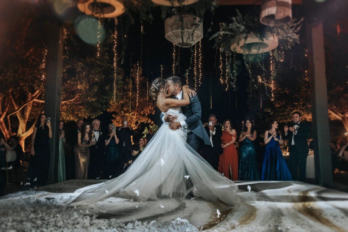 Baile nocturno de novios bajo luces colgantes