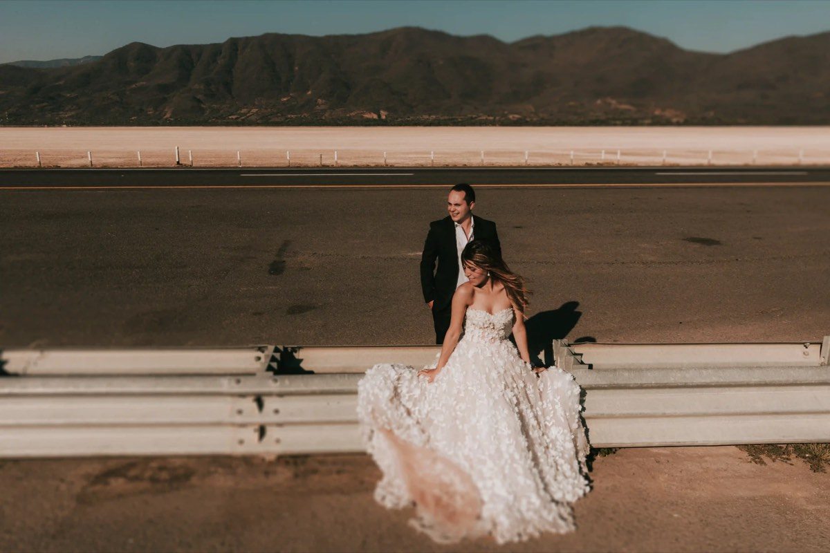 Pareja de novios en una carretera con paisaje desértico