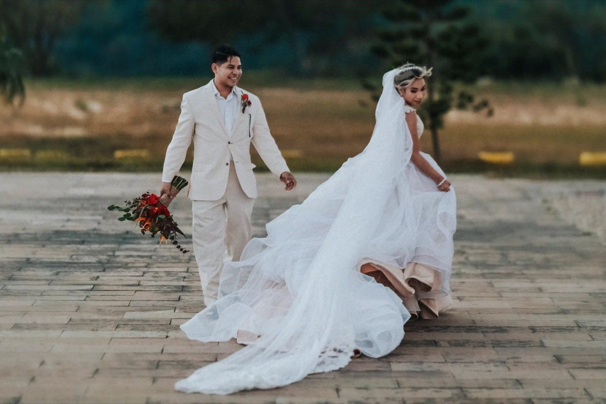 Novios caminando con ramo de flores, boda documental