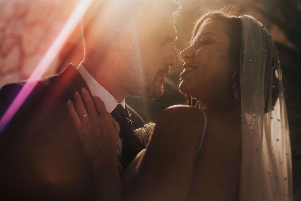 Novios abrazados bajo una luz cálida y dorada