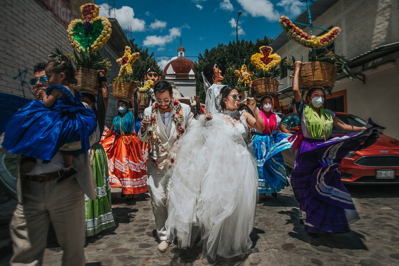 Calenda de boda por las calles de Mitla con mujeres cargando canastas de flores