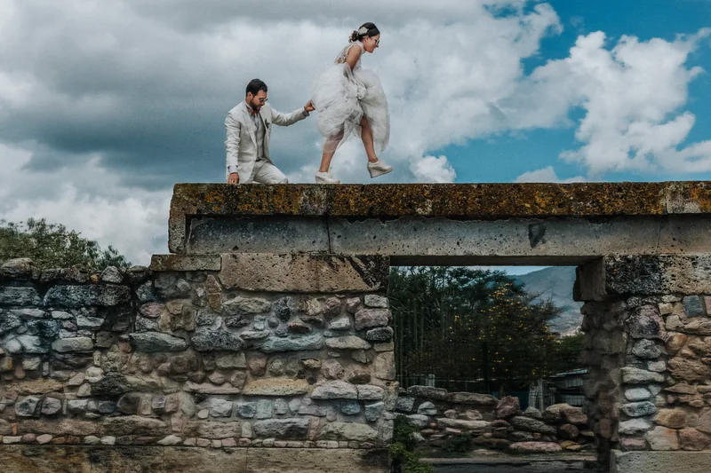 Novios caminando sobre un muro de piedra zapoteca en Mitla, Oaxaca