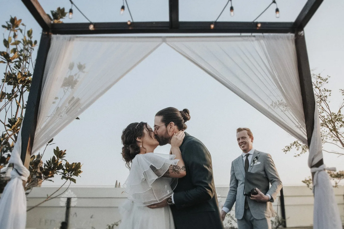 Laura y Andrew besándose bajo el arco de su ceremonia en la terraza de Casa Pedro Loza