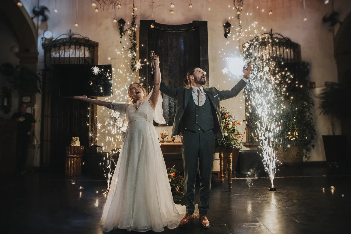 Laura y Andrew celebrando con chispas al entrar a su fiesta de bodas