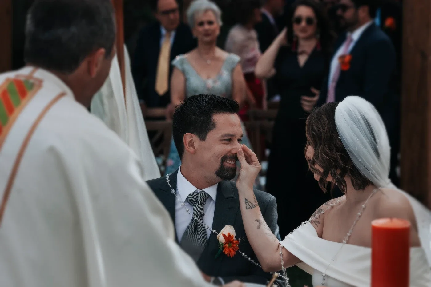 Iván riendo mientras Lucía le toca la cara durante la ceremonia religiosa