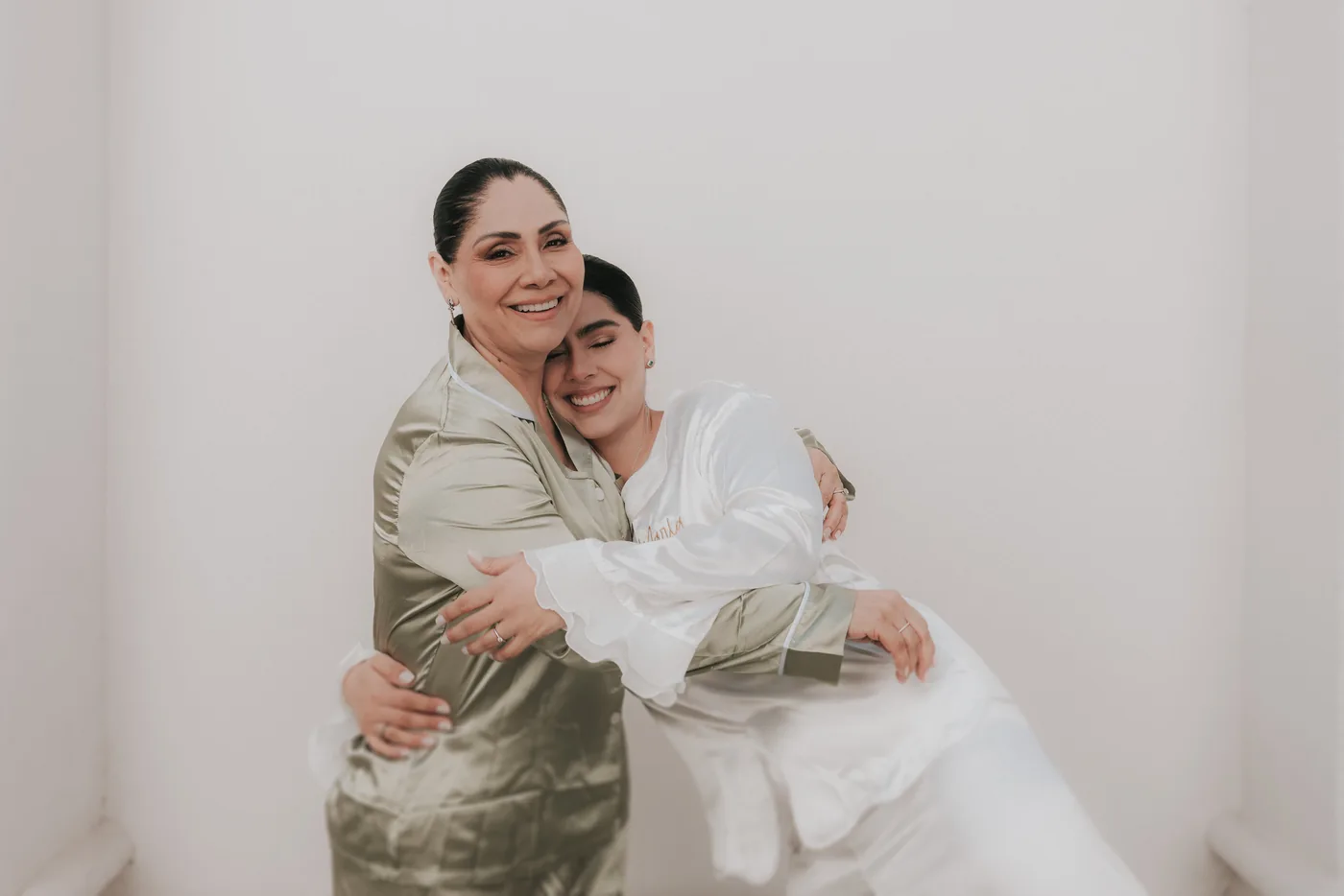 Marla y su mamá, las dos en pijama, abrazadas y riendo contra una pared blanca