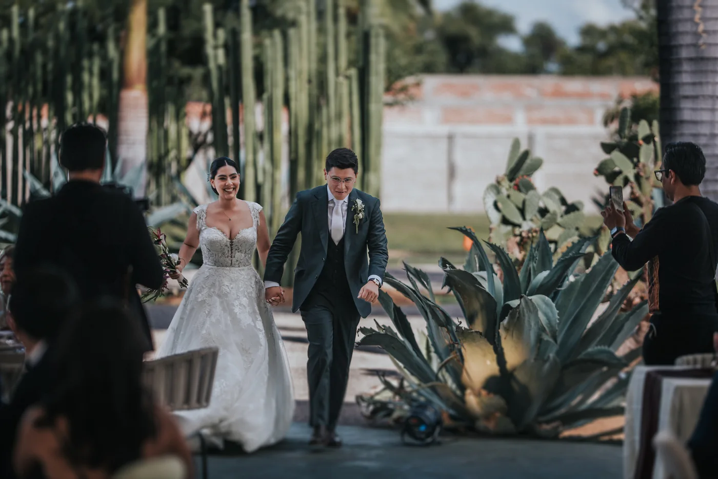 Marla y Edy entran a su recepción en Lisianthus Jardín de Eventos entre agaves y órganos