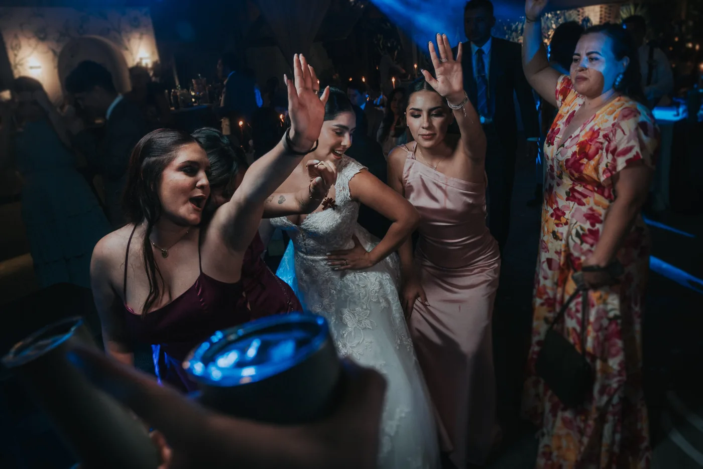 Las damas bailan con los brazos en alto junto a Marla durante la fiesta