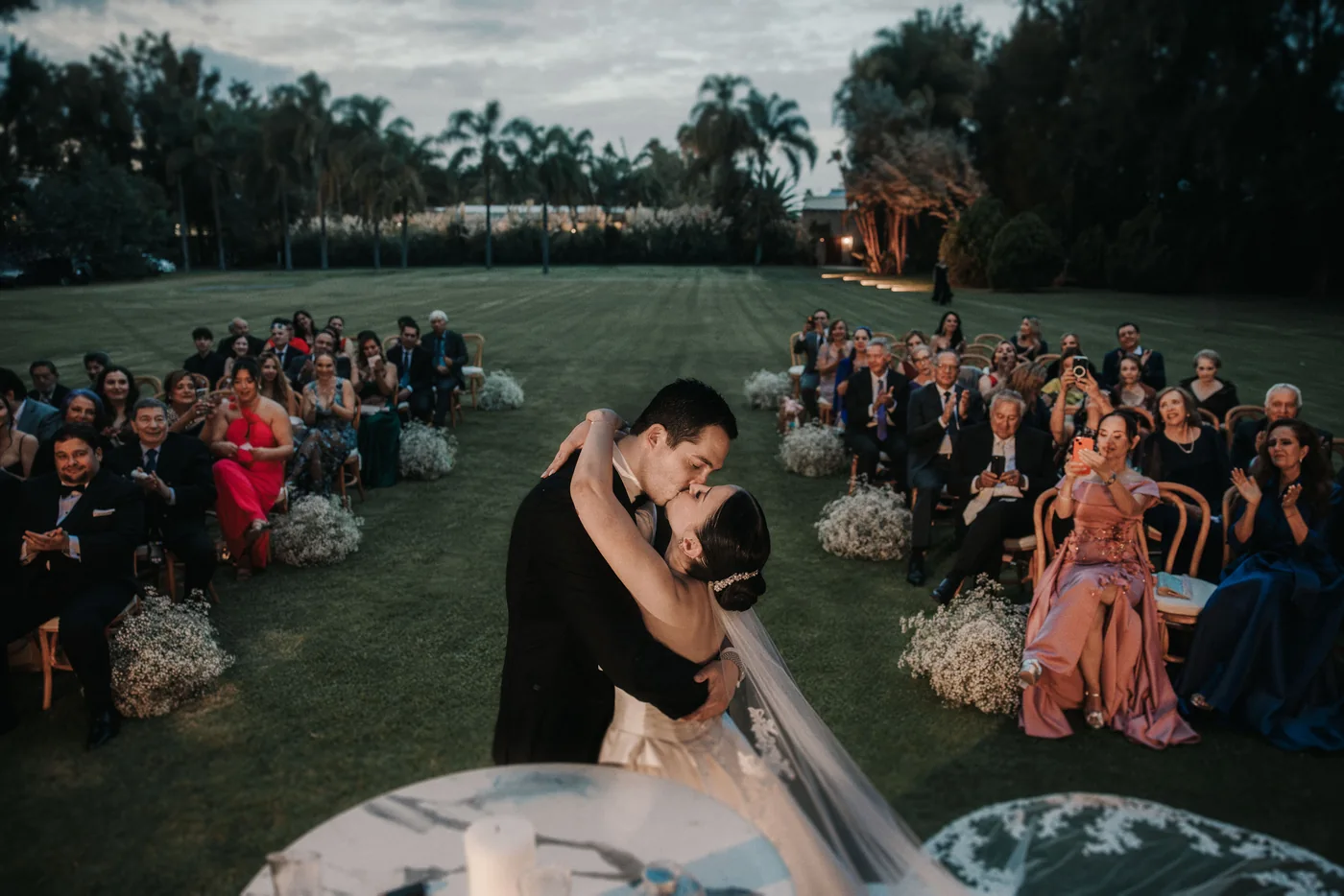 El beso de Sofi y Diego al final de la ceremonia, ya anocheciendo, con los invitados alrededor