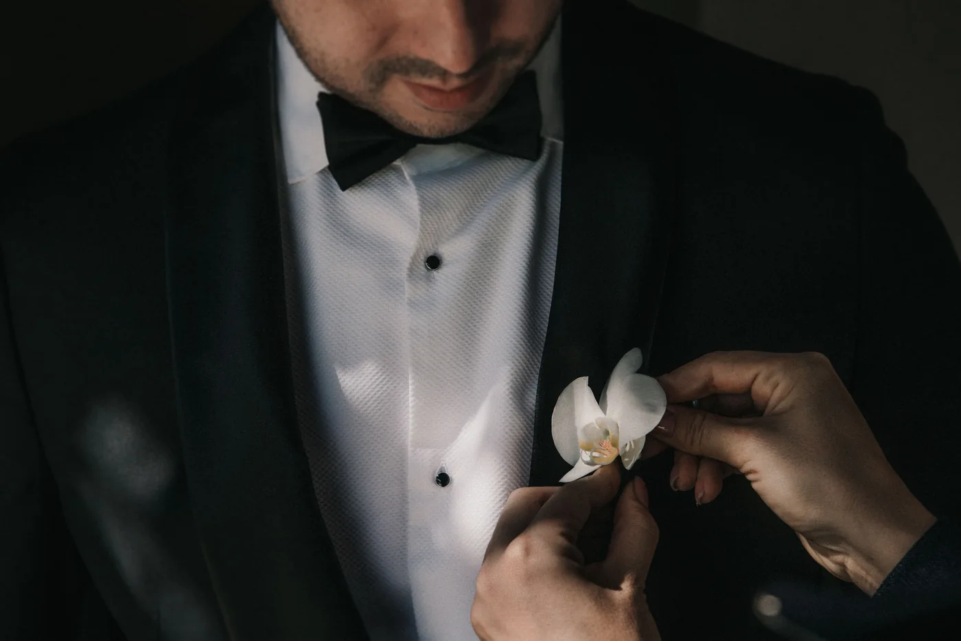 Una mano le prende la orquídea blanca en la solapa a Diego
