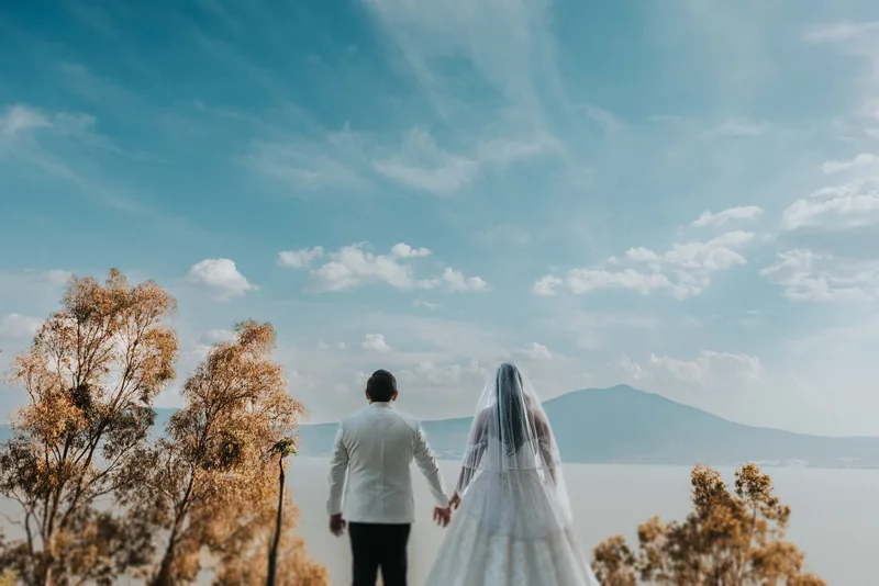 Novios de espaldas frente al lago de Chapala al atardecer, en Monte Coxala