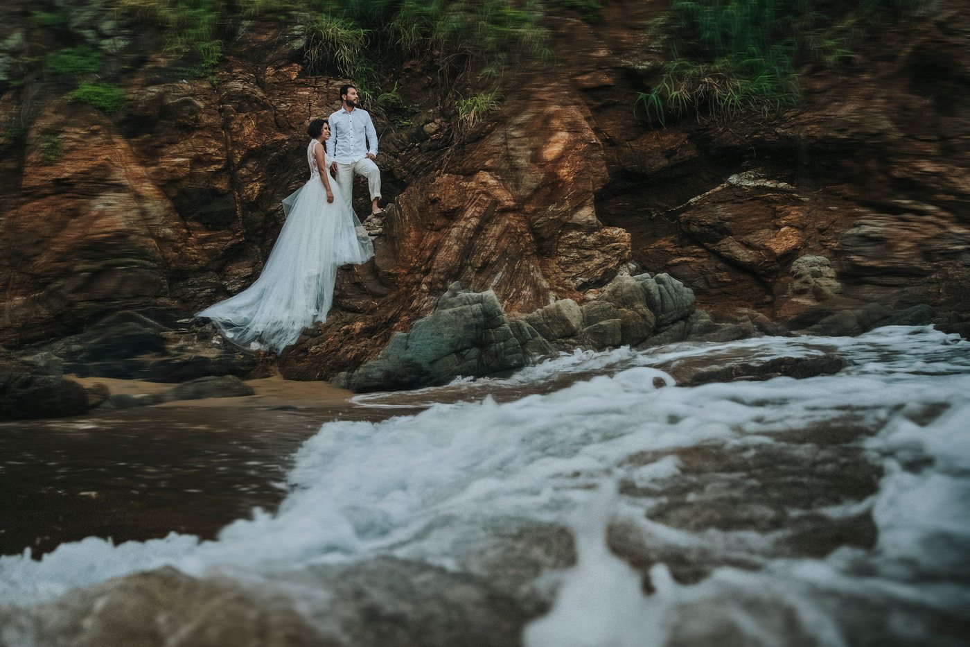 Pareja de novios sobre las rocas frente al mar en Mazunte, costa de Oaxaca